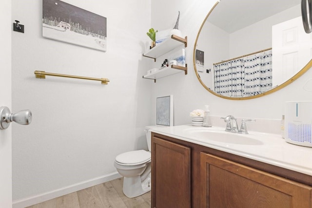 bathroom with baseboards, toilet, a shower with curtain, wood finished floors, and vanity