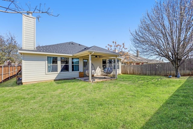 rear view of property featuring a patio area, a fenced backyard, a ceiling fan, and a yard