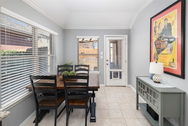 dining room featuring baseboards, light tile patterned floors, vaulted ceiling, and crown molding