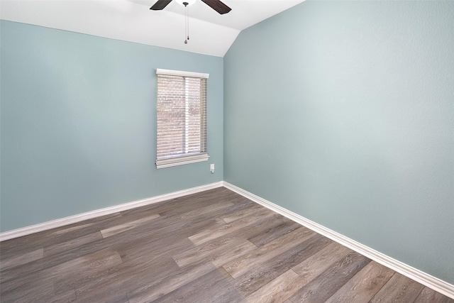 unfurnished room featuring vaulted ceiling, ceiling fan, dark wood-type flooring, and baseboards