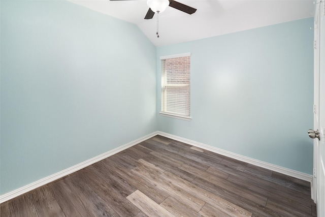 spare room featuring dark wood-type flooring, lofted ceiling, ceiling fan, and baseboards