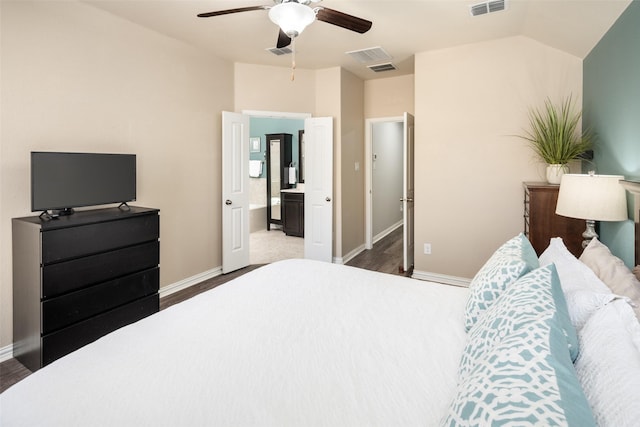 bedroom featuring lofted ceiling, visible vents, baseboards, and wood finished floors