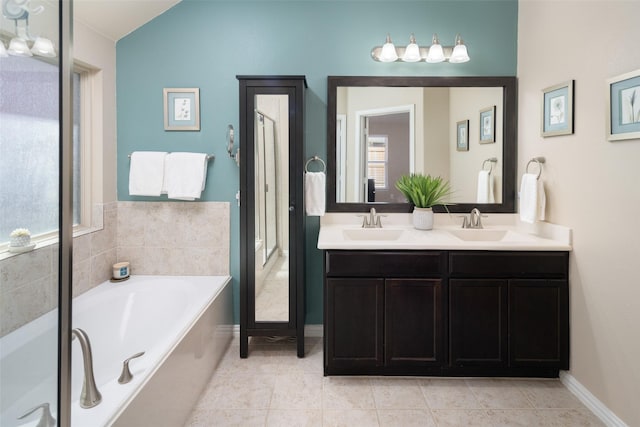 bathroom featuring tile patterned flooring, plenty of natural light, a sink, and a bath