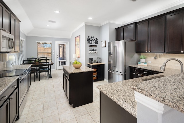 kitchen featuring a sink, visible vents, appliances with stainless steel finishes, light stone countertops, and crown molding