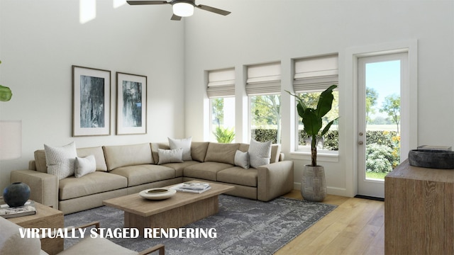 living room featuring ceiling fan, a high ceiling, plenty of natural light, and wood finished floors