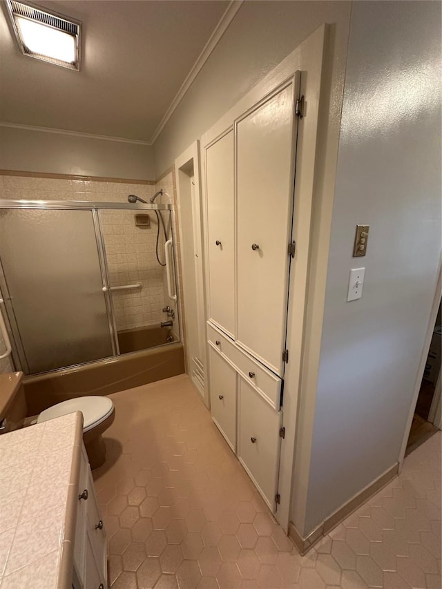 bathroom featuring toilet, bath / shower combo with glass door, visible vents, vanity, and crown molding