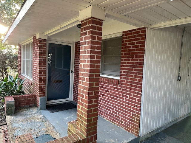 view of exterior entry featuring brick siding