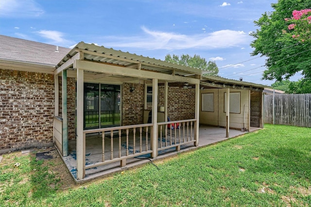 exterior space with brick siding, fence, a lawn, and a patio