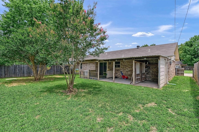 rear view of property with a patio area, a fenced backyard, brick siding, and a yard