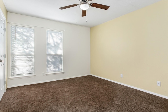 empty room featuring ceiling fan, baseboards, and dark colored carpet