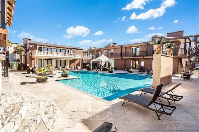 pool with a patio, a residential view, and stairway
