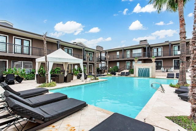 community pool with a patio area and a residential view