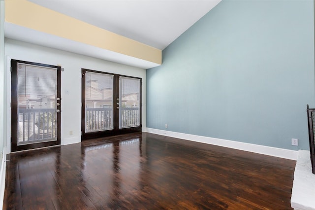 unfurnished room with lofted ceiling, french doors, baseboards, and wood finished floors