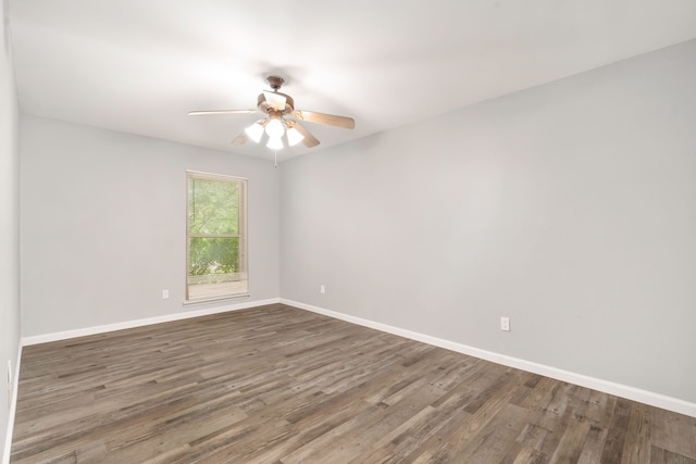 empty room featuring wood finished floors, a ceiling fan, and baseboards