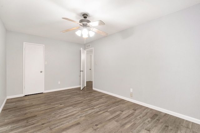 unfurnished room featuring ceiling fan, visible vents, baseboards, and wood finished floors