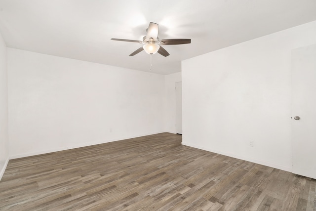 spare room with wood finished floors and a ceiling fan