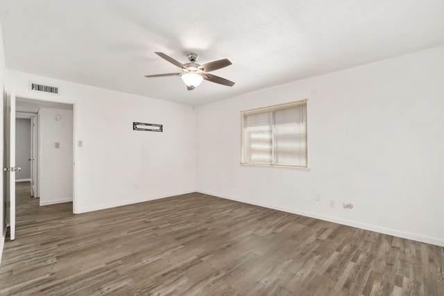 unfurnished room with visible vents, ceiling fan, baseboards, and wood finished floors