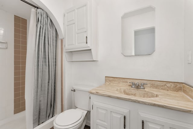 bathroom with toilet, a stall shower, and vanity