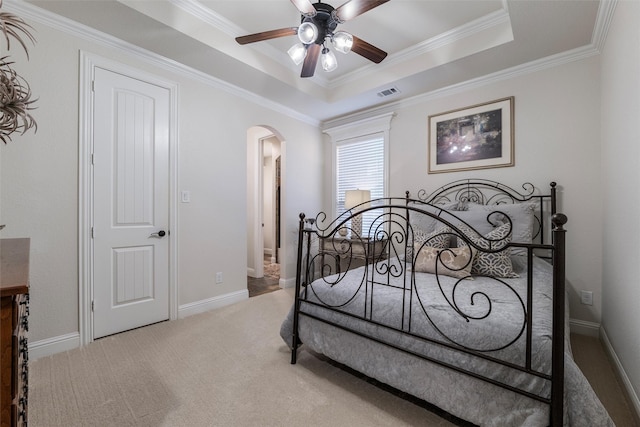 bedroom with arched walkways, baseboards, a tray ceiling, carpet, and crown molding