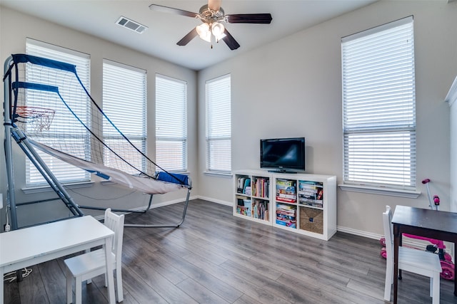 rec room with a ceiling fan, baseboards, visible vents, and wood finished floors