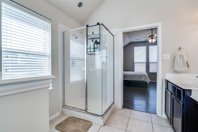 bathroom featuring ensuite bathroom, vaulted ceiling, a shower stall, vanity, and tile patterned flooring