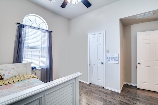 bedroom featuring a ceiling fan, baseboards, visible vents, and wood finished floors