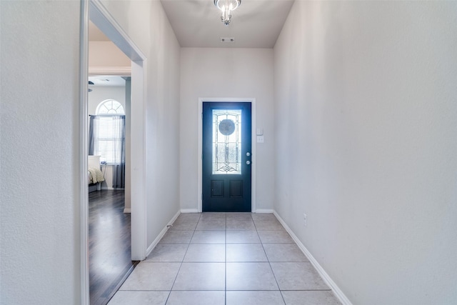 foyer entrance featuring light tile patterned floors and baseboards