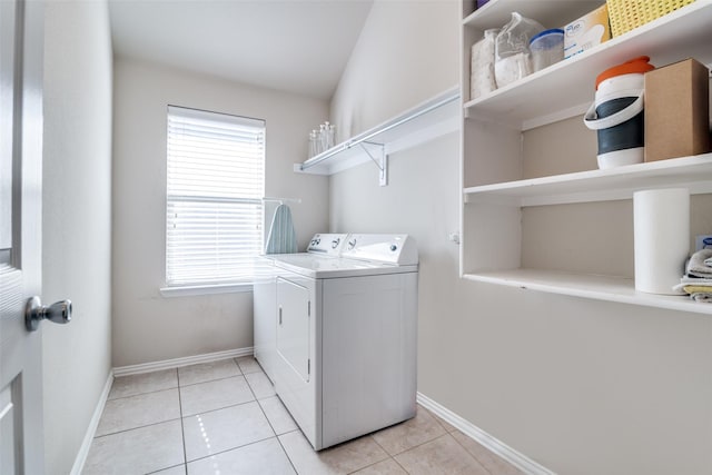 laundry room with laundry area, light tile patterned floors, baseboards, and washing machine and clothes dryer