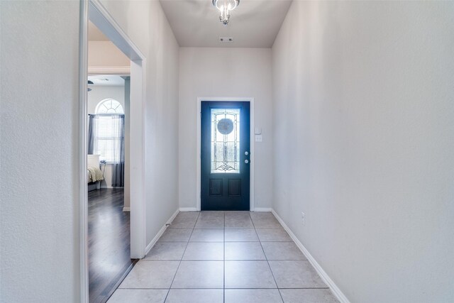 living area featuring a wealth of natural light, a tile fireplace, wood finished floors, and visible vents