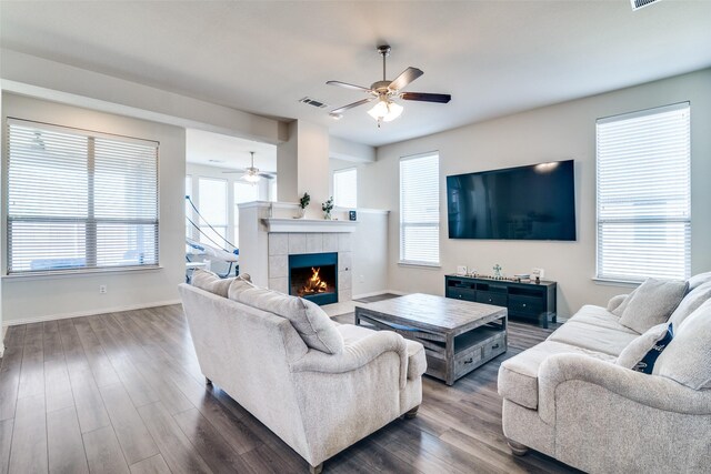 living area featuring light wood-style flooring, stairs, visible vents, and a ceiling fan