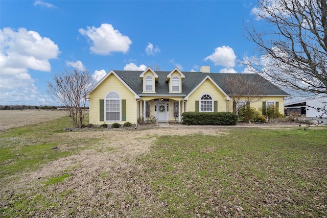 view of front of home featuring a shingled roof, a chimney, and a front yard