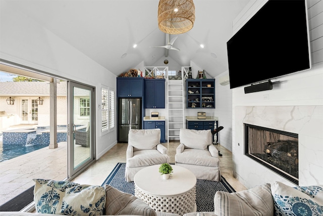 living room featuring ceiling fan, high vaulted ceiling, and a high end fireplace