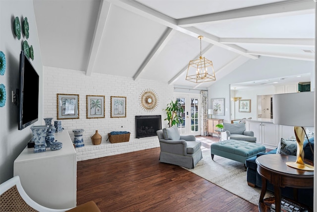 living area featuring lofted ceiling with beams, brick wall, wood finished floors, french doors, and a brick fireplace