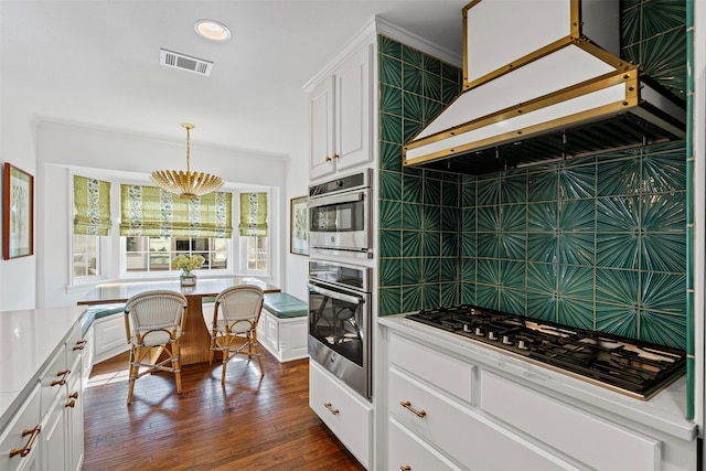 kitchen featuring white cabinets, light countertops, decorative backsplash, breakfast area, and dark wood finished floors