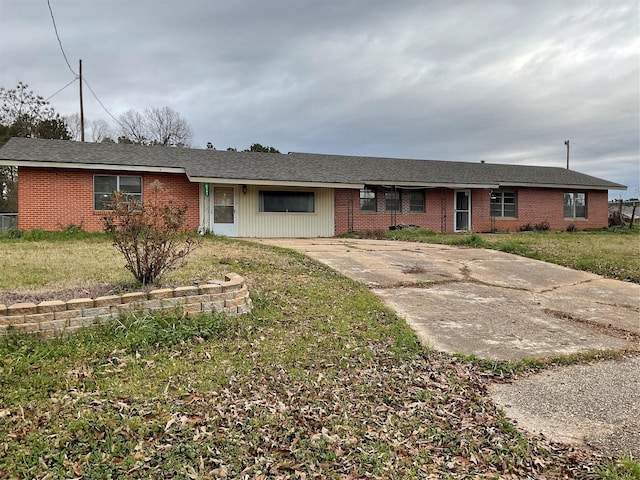 ranch-style house with a front lawn and brick siding