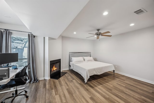 bedroom featuring baseboards, visible vents, wood finished floors, and recessed lighting