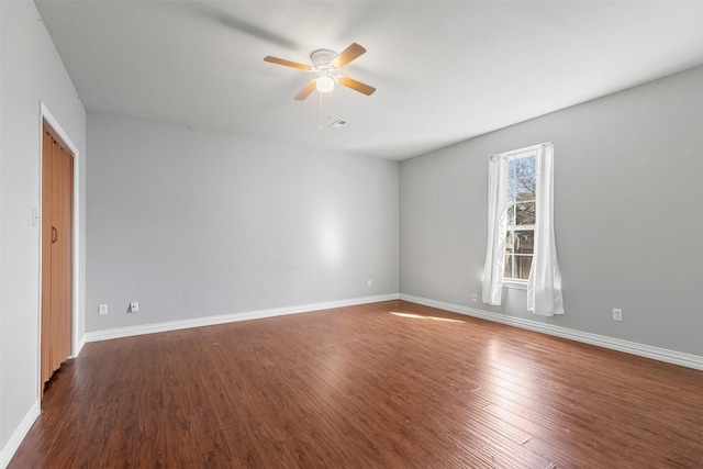 spare room with ceiling fan, wood finished floors, and baseboards