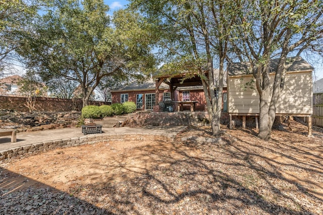 view of yard featuring an outdoor fire pit, a patio area, and fence