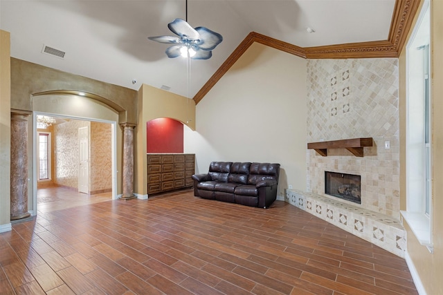 unfurnished living room featuring a large fireplace, wood finish floors, decorative columns, and visible vents