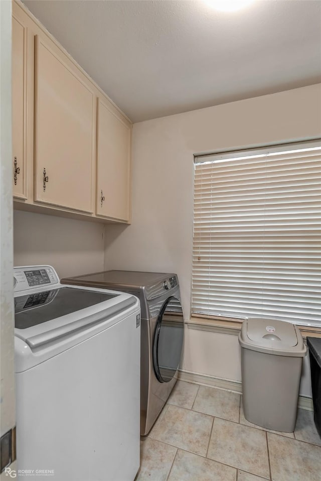 laundry room with cabinet space, light tile patterned flooring, and independent washer and dryer