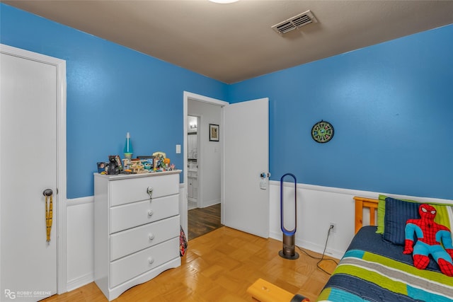 bedroom with visible vents and wood finished floors