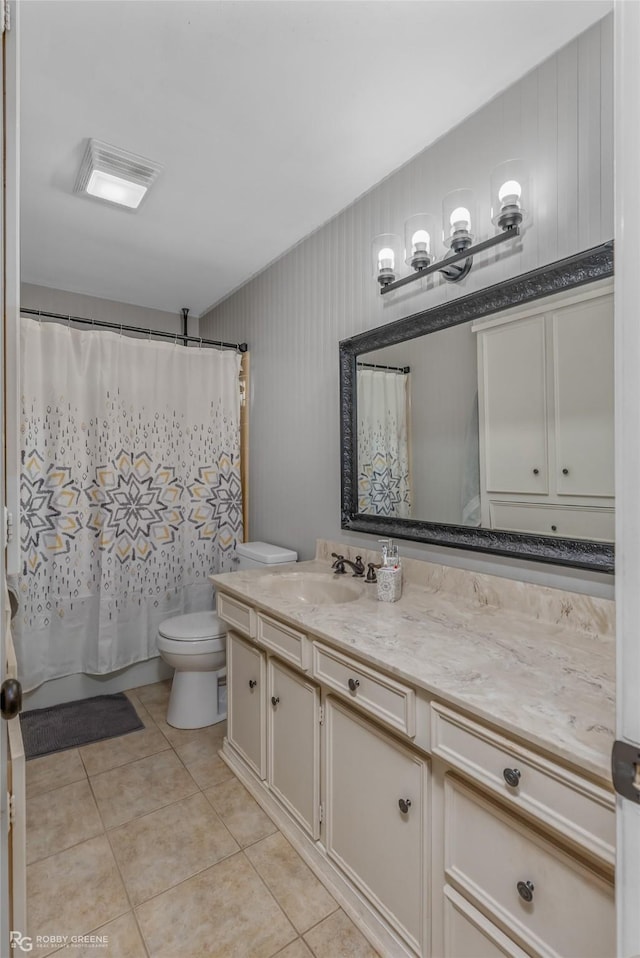 bathroom with toilet, tile patterned flooring, and vanity