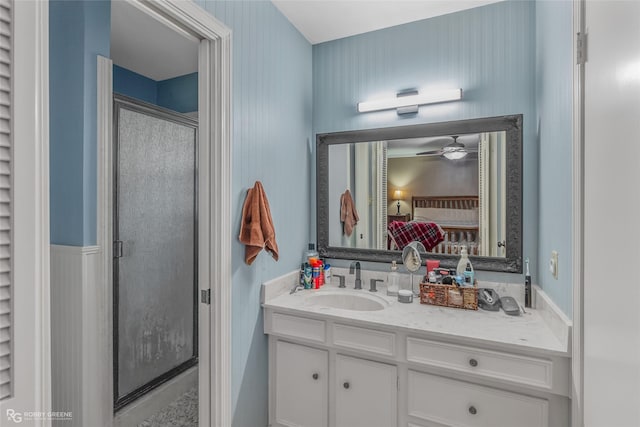 ensuite bathroom with ceiling fan, a stall shower, connected bathroom, and vanity