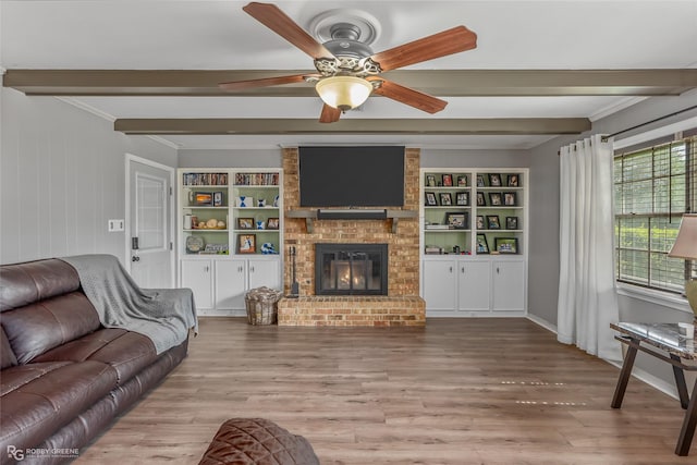 living room featuring beam ceiling, a fireplace, and wood finished floors