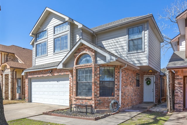 traditional home featuring a shingled roof, concrete driveway, brick siding, and an attached garage