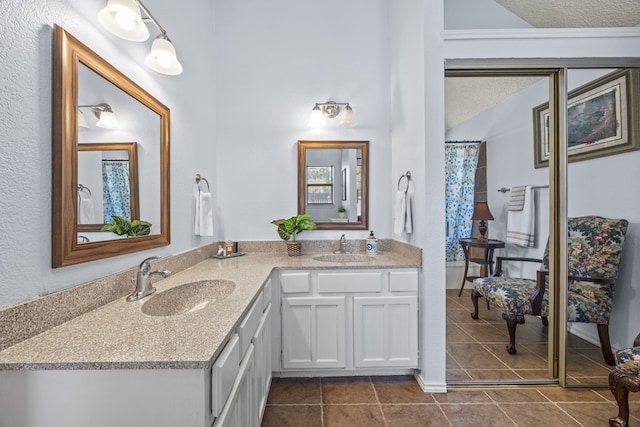 full bathroom with double vanity, tile patterned flooring, and a sink