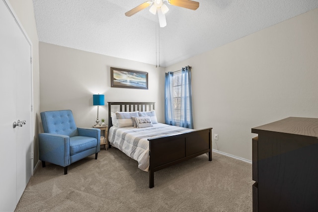 bedroom featuring vaulted ceiling, ceiling fan, a textured ceiling, and carpet flooring