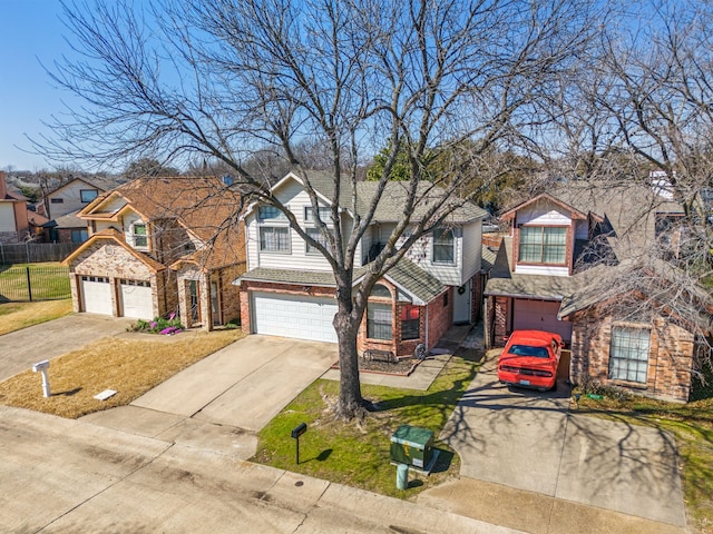 traditional-style house featuring concrete driveway, a residential view, an attached garage, fence, and brick siding