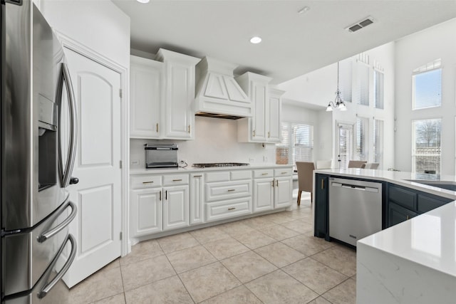 kitchen with light countertops, appliances with stainless steel finishes, custom exhaust hood, and white cabinets