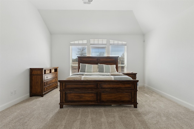 bedroom featuring lofted ceiling, light carpet, and baseboards